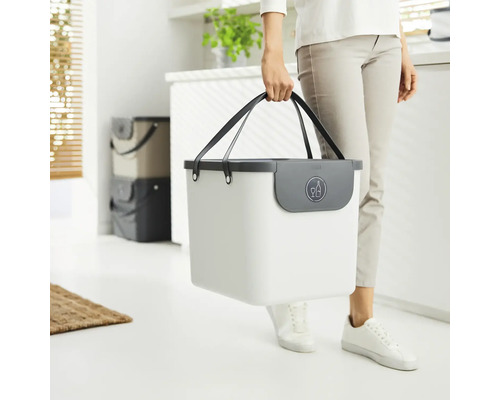 Person trägt einen weißen Recyclingbehälter mit Flaschensymbol