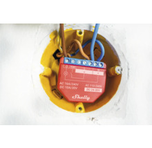 Shelly Logo in einer gelben Unterputzdose mit Kabeln