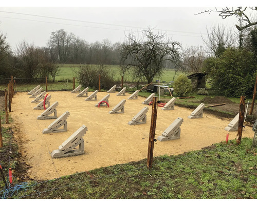 Bauplatzvorbereitung mit Betonfundamenten für ein Gartenprojekt im Außenbereich.