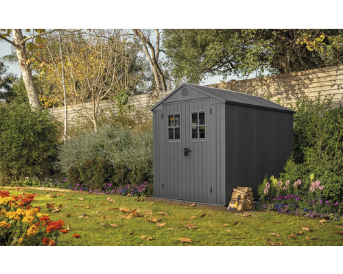 Gartenschuppen im Garten mit Holzstapel