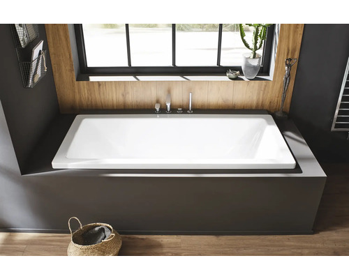 Eingebaute Badewanne in modernem Badezimmer mit Holzverkleidung und Korb