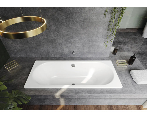 Einbau-Badewanne in einem Badezimmer mit grauen Fliesen und dekorativen Elementen.