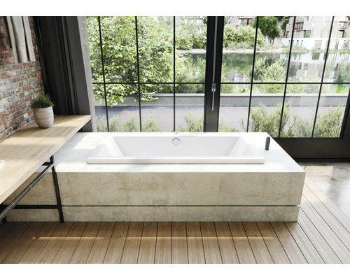 Rechteckige Badewanne in einem hellen Badezimmer mit Holzboden und großem Fenster mit Blick ins Grüne.