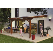 Überdachte Terrasse mit Gartenmöbeln, Grill und Pflanzgefäßen an einem Wohnhaus
