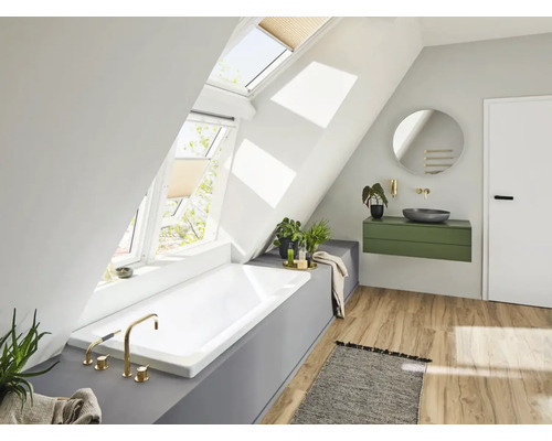Badezimmer mit Dachfenstern, Badewanne, Waschtisch und Spiegel in einem hellen Raum