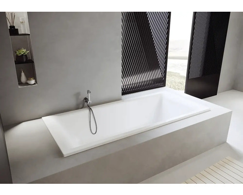 Rechteckige Badewanne in einem hellen Badezimmer mit Duschkopf