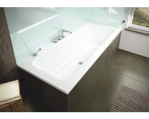 Eingebaute Badewanne mit Armatur und Duschwand aus Glas in einem hellen Badezimmer.