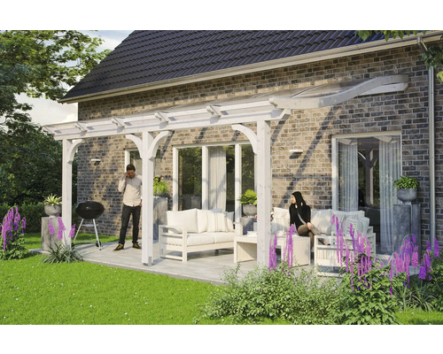 Terrassenüberdachung SKAN HOLZ Venezia 541x239 cm weiß Terrasse mit Holzpergola und Sitzgruppe auf einer gepflasterten Fläche neben einem Haus.