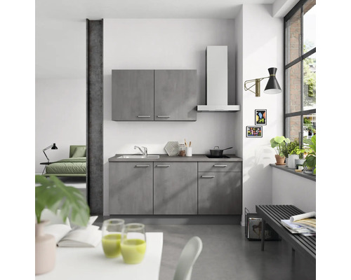 Moderne Küche mit grauen Schränken, Dunstabzugshaube und Spüle in einem hellen Raum.