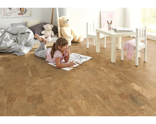 Helles Kinderzimmer mit Korkboden, Kindermöbeln und einem spielenden Mädchen.