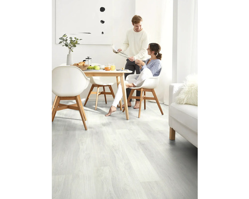 Heller Raum mit Holzboden, Esstisch und Paar beim Frühstück