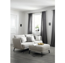 Wohnzimmer mit Sofa, Kissen, Hocker und Vorhängen