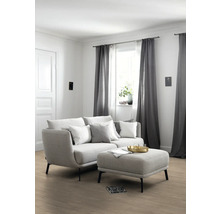 Wohnzimmer mit Sofa, Kissen, Hocker und Vorhängen für ein gemütliches Ambiente