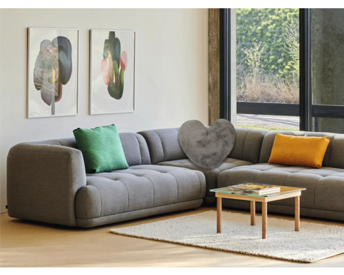 Wohnzimmer mit grauer Eckcouch, Kissen und Couchtisch