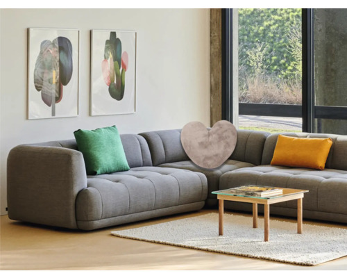 Wohnzimmer mit grauer Eckcouch, Zierkissen, Couchtisch und abstrakten Wandbildern