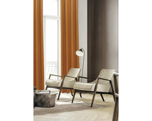 Wohnzimmer mit zwei Sesseln, Stehlampe und Vorhängen vor dem Fenster.