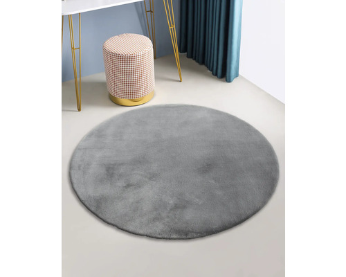 Grauer runder Teppich in einer Raumdekoration.