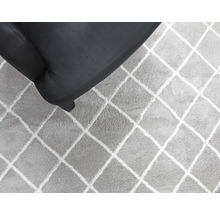 Teppich mit Rautenmuster neben Sessel