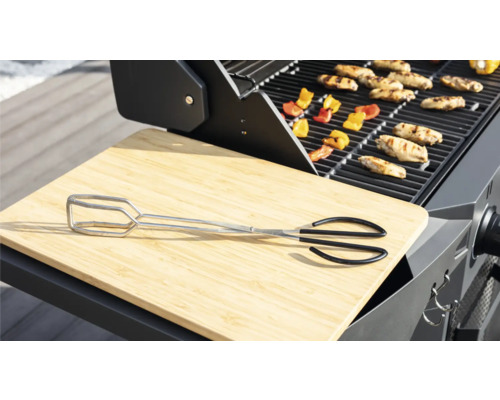 Grillszene mit Grillzange, Schneidebrett, Grillgut