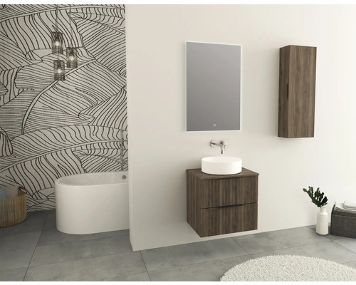 Modernes Badezimmer mit Waschtisch, Spiegel, Hängeschrank und freistehender Badewanne vor einer Wand mit Blättertapete