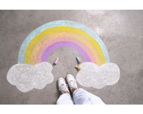 Kreidezeichnung eines Regenbogens und Wolken auf Betonboden, umgeben von Füßen und Kreidestücken