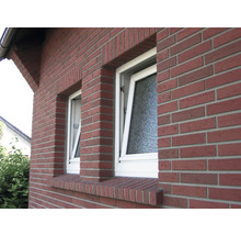 Außenansicht eines Ziegelhauses mit zwei Fenstern