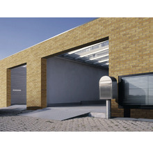 Gebäudeansicht mit Ziegelmauerwerk, Garage und Briefkasten