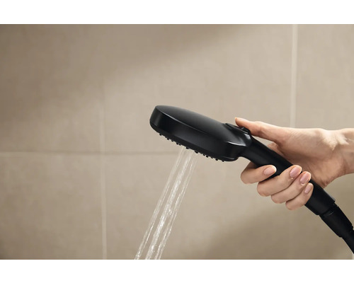 Hand hält schwarzen Duschkopf mit laufendem Wasser