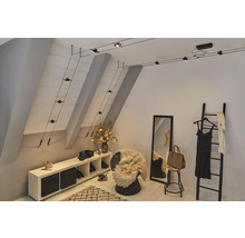 Innenraum mit Seilsystemleuchte, Spiegel, Leiter und Aufbewahrungsmöbeln in einem hellen Raum.