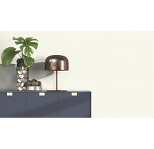 Dekoratives Arrangement mit Tisch, Lampe, Vase und Pflanzen auf einem Schrank.