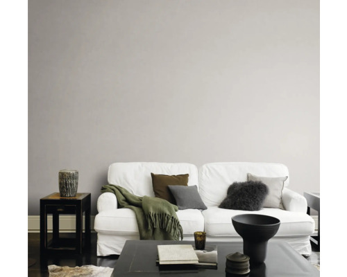 Wohnzimmer mit weißem Sofa, Kissen und Couchtisch