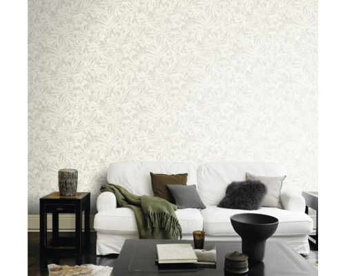 Helles Wohnzimmer mit gemusterter Tapete, weißem Sofa und dunklem Couchtisch