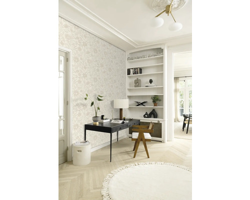 Ein heller Arbeitsbereich mit floral gemusterter Tapete, einem schwarzen Schreibtisch und einem runden Teppich