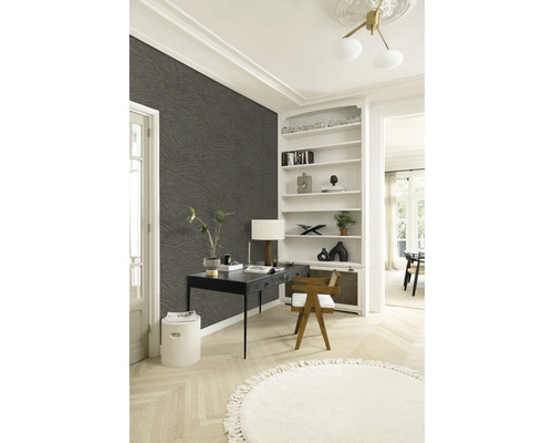 Helles Zimmer mit Schreibtisch, Bücherregal und gemusterter Tapete für ein stilvolles Arbeitsambiente.