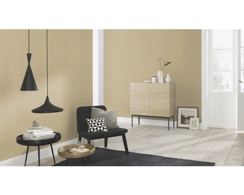 Wohnzimmer mit Pendelleuchten, Stuhl, Teppich und Kommode vor einer tapezierten Wand