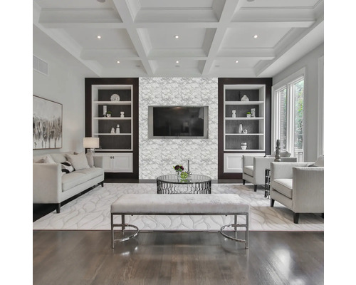 Helles Wohnzimmer mit Sofa, Sesseln, Couchtisch, Bank und eingebauten Regalen