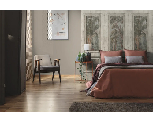 Helles Schlafzimmer mit Bett, Sessel und dekorativer Wandtapete mit Waldmotiven für eine freundliche Atmosphäre.