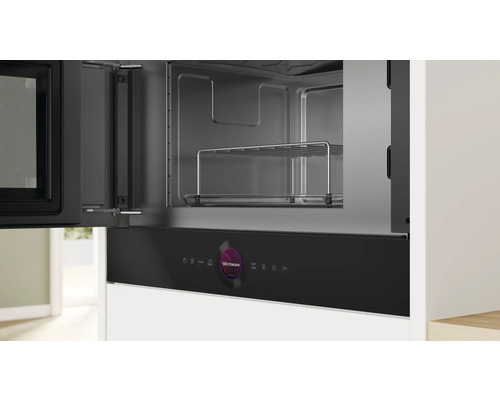 Eingebaute Mikrowelle mit geöffneter Tür und Garraum mit Gitterrost