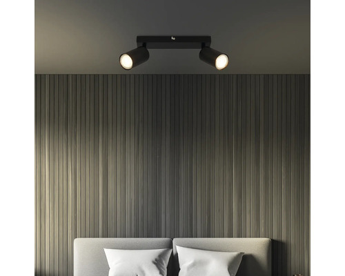 Deckenleuchte mit zwei Strahlern über einem Bett