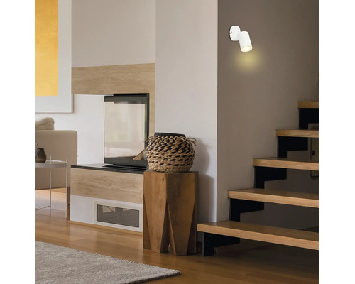 Wohnzimmer mit Kamin, Treppe und Wandleuchte