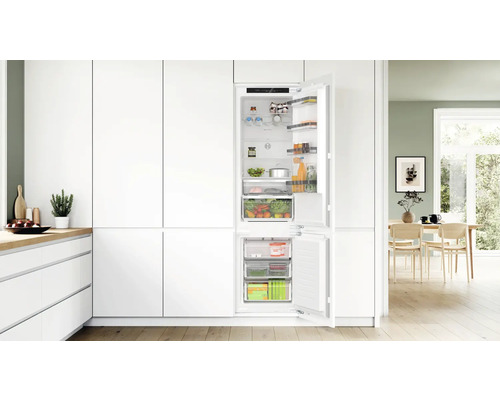 Integrierter Kühlschrank mit geöffneter Tür in einer weißen Küche