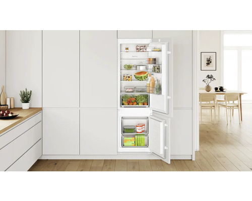 Einbaukühlschrank mit geöffneter Tür in heller Küche, gefüllt mit Lebensmitteln