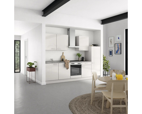 Helle Küche mit Einbauschränken, Dunstabzugshaube und Esstisch in einem modernen Wohnraum.