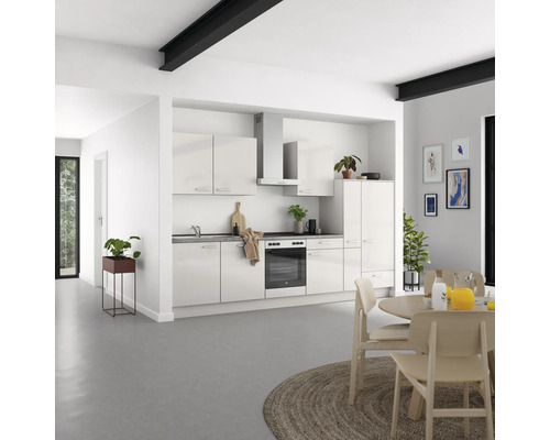 Helle Küche mit Küchenschränken, Esstisch und Dekoration in einem offenen Wohnraum.