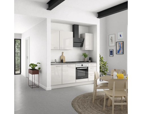 Helle Küche mit Einbauküche, Dunstabzugshaube und Esstisch.