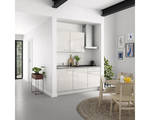 Helle Küche mit Küchenschränken, Dunstabzugshaube und Esstisch im modernen Wohnraum.