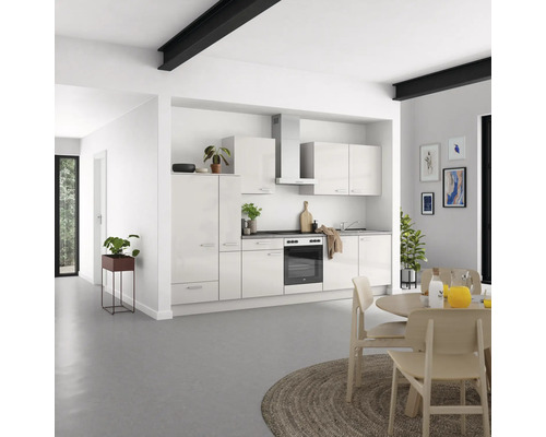 Moderne Küche mit weißen Schränken, Esstisch und Stühlen in hellem Raum.