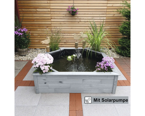 Achteckiger Teich mit Solarbetriebener Pumpe und Holzumrandung im Garten