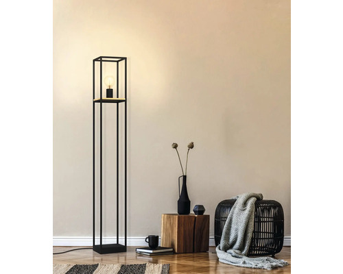 Stehleuchte mit schwarzem Metallgestell und eingeschalteter Glühbirne