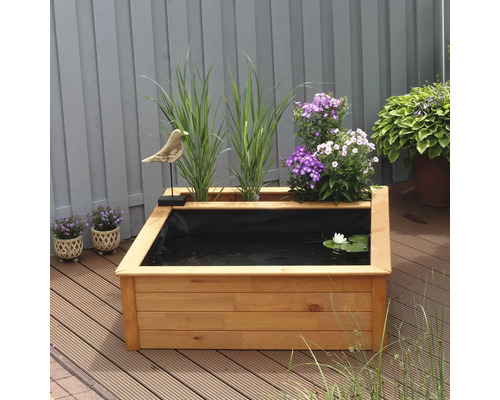 Quadratischer Gartenteich aus Holz mit Pflanzen und Dekoration auf einer Terrasse